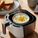 Sunny-side up fried egg cooked in an air fryer, showcasing its golden yolk and crispy edges.