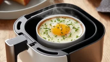 Sunny-side up fried egg cooked in an air fryer, showcasing its golden yolk and crispy edges.