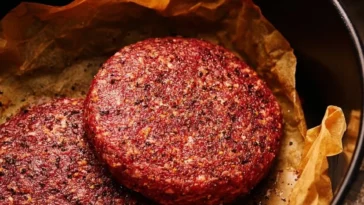 Delicious air fryer juicy burgers served on a plate with fresh toppings