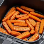 Air fryer roasted carrots topped with herbs and spices in a bowl