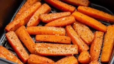 Air fryer roasted carrots topped with herbs and spices in a bowl