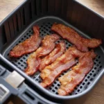 Crispy air fryer bacon cooking in a modern air fryer.