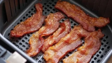 Crispy air fryer bacon cooking in a modern air fryer.