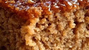 12-slice oatmeal ginger cake with ginger frosting on a wooden table