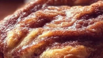 Loaf of homemade Amish Cinnamon Bread with cinnamon swirl on a wooden table