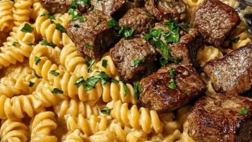 Delicious buttery steak skillet served with creamy alfredo spirals.