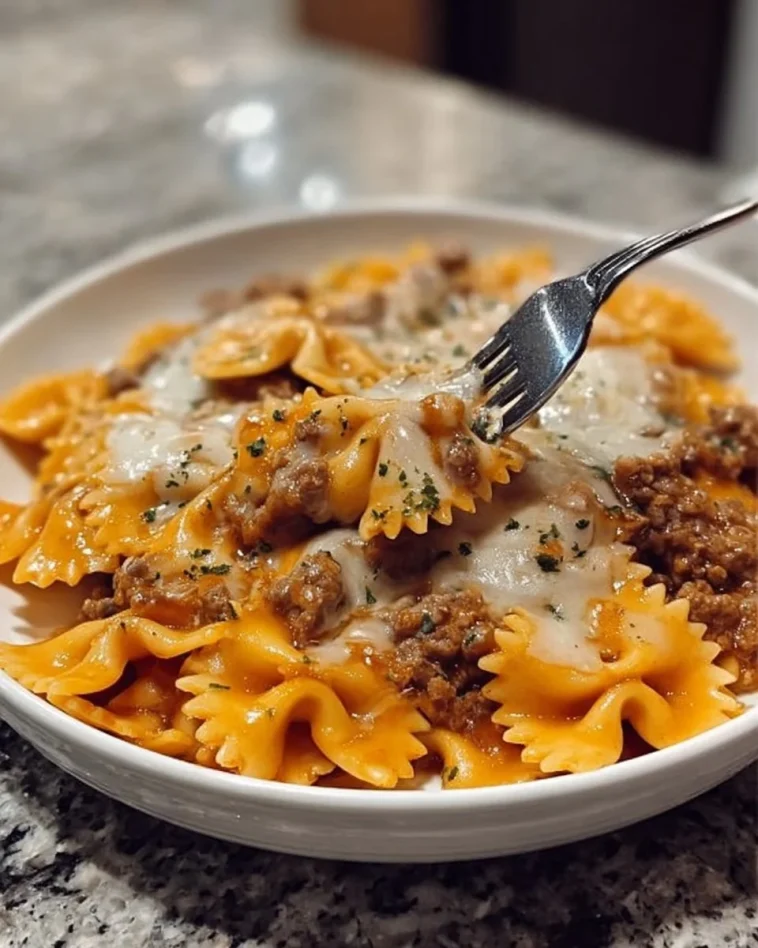 Cajun garlic butter beef served with cheesy bowtie pasta on a plate.