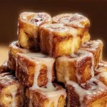 Cinnamon Roll French Toast Bites served with syrup and berries on a plate