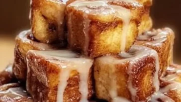 Cinnamon Roll French Toast Bites served with syrup and berries on a plate