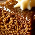 Delicious slice of easy gingerbread cake topped with cream and spices