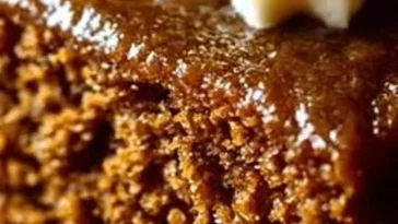 Delicious slice of easy gingerbread cake topped with cream and spices