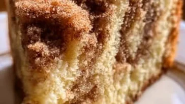 Delicious sour cream coffee cake displayed on a white plate, perfect for any occasion.