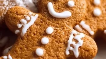 Baked soft gingerbread cookies decorated with icing on a wooden table