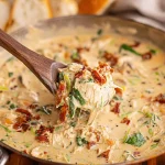 Bowl of creamy Crack Chicken Soup with herbs and toppings